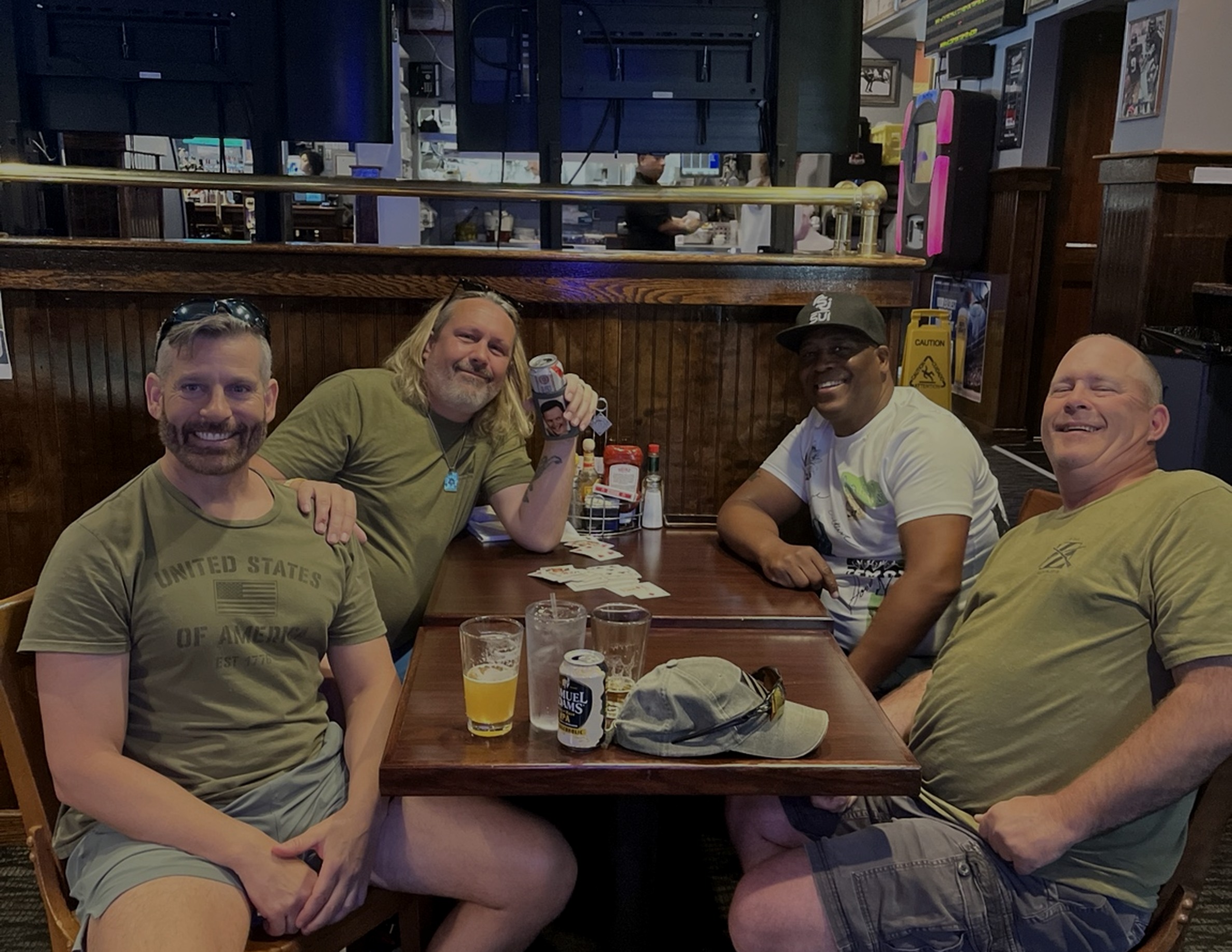 Army friends gathered around a table playing cards