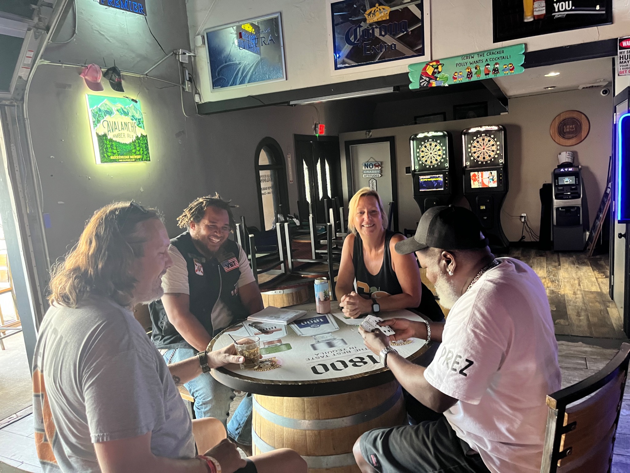 Four people playing Spades around a barrel table in Florida